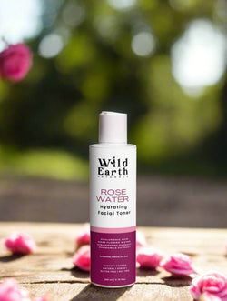 Wild Earth Rose Water facial toner bottle on a brown background with natural elements.